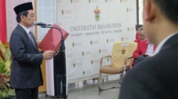 Foto: Rektor Unhas, Prof. Jamaluddin Jompa, menyerahkan SK Guru Besar kepada Prof. Dr. Herawaty. (Dok: Unhas).